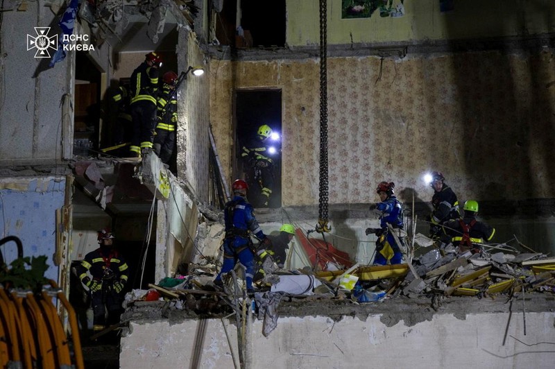 Tim penyelamat bekerja di lokasi sebuah gedung apartemen yang terkena serangan udara Rusia di Kyiv, Ukraina, Jumat (1/8/2025). (Handout via REUTERS)