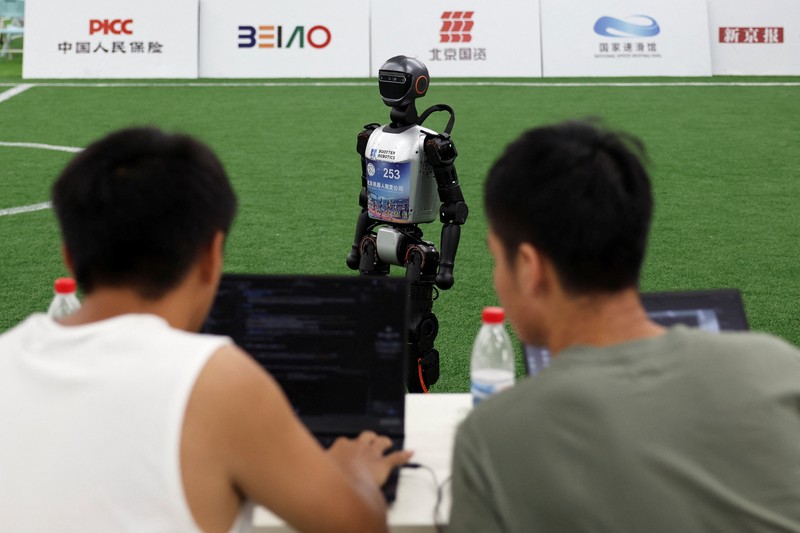 Robot humanoid T1 yang dikembangkan oleh Booster Robotics beraksi di lapangan sepak bola, selama latihan persiapan untuk kompetisi sepak bola di World Humanoid Robot Games perdana, di National Speed Skating Oval di Beijing, Cina, 1 Agustus 2025. (REUTERS/Florence Lo)