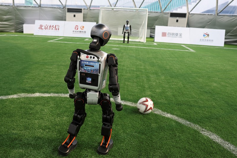 Robot humanoid T1 yang dikembangkan oleh Booster Robotics beraksi di lapangan sepak bola, selama latihan persiapan untuk kompetisi sepak bola di World Humanoid Robot Games perdana, di National Speed Skating Oval di Beijing, Cina, 1 Agustus 2025. (REUTERS/Florence Lo)