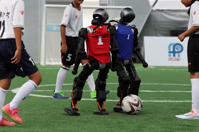 Robot humanoid T1 yang dikembangkan oleh Booster Robotics beraksi di lapangan sepak bola, selama latihan persiapan untuk kompetisi sepak bola di World Humanoid Robot Games perdana, di National Speed Skating Oval di Beijing, Cina, 1 Agustus 2025. (REUTERS/Florence Lo)