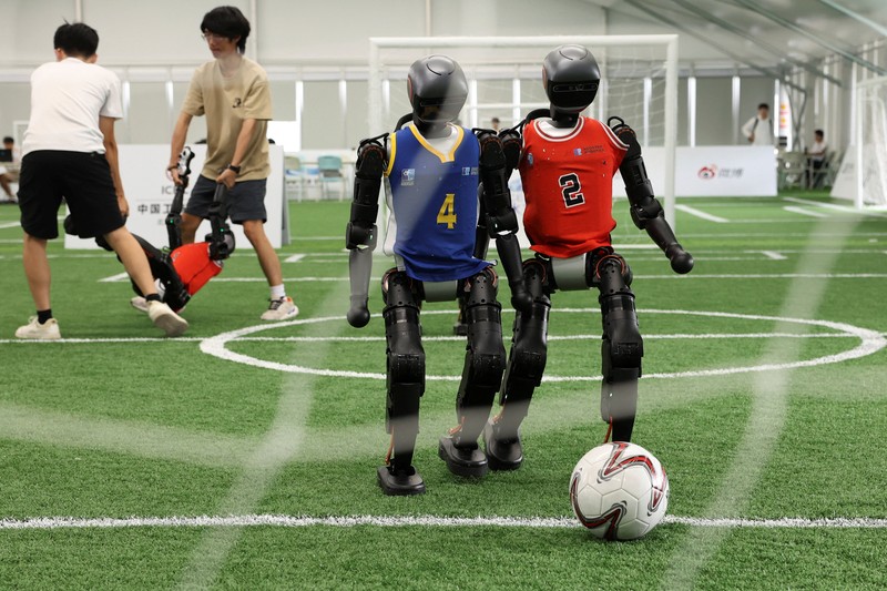 Robot humanoid T1 yang dikembangkan oleh Booster Robotics beraksi di lapangan sepak bola, selama latihan persiapan untuk kompetisi sepak bola di World Humanoid Robot Games perdana, di National Speed Skating Oval di Beijing, Cina, 1 Agustus 2025. (REUTERS/Florence Lo)