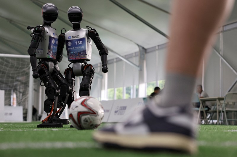 Robot humanoid T1 yang dikembangkan oleh Booster Robotics beraksi di lapangan sepak bola, selama latihan persiapan untuk kompetisi sepak bola di World Humanoid Robot Games perdana, di National Speed Skating Oval di Beijing, Cina, 1 Agustus 2025. (REUTERS/Florence Lo)