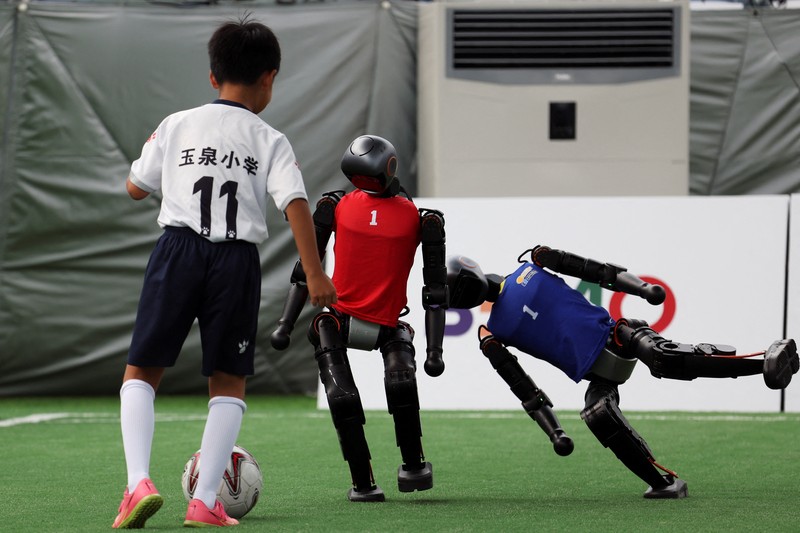 Robot humanoid T1 yang dikembangkan oleh Booster Robotics beraksi di lapangan sepak bola, selama latihan persiapan untuk kompetisi sepak bola di World Humanoid Robot Games perdana, di National Speed Skating Oval di Beijing, Cina, 1 Agustus 2025. (REUTERS/Florence Lo)