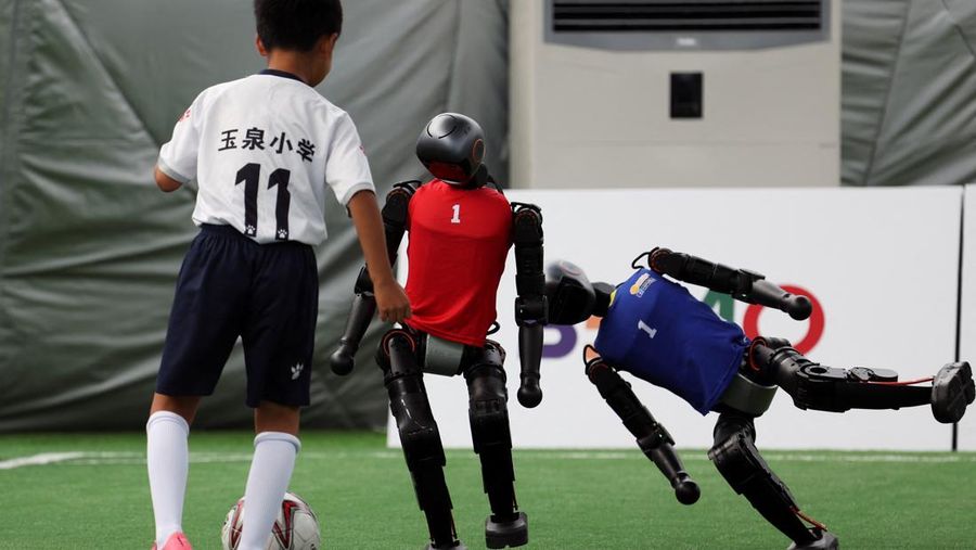 Robot humanoid T1 yang dikembangkan oleh Booster Robotics beraksi di lapangan sepak bola, selama latihan persiapan untuk kompetisi sepak bola di World Humanoid Robot Games perdana, di National Speed Skating Oval di Beijing, Cina, 1 Agustus 2025. (REUTERS/Florence Lo)