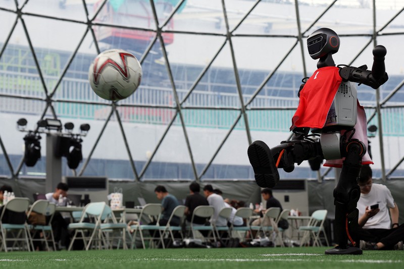 Robot humanoid T1 yang dikembangkan oleh Booster Robotics beraksi di lapangan sepak bola, selama latihan persiapan untuk kompetisi sepak bola di World Humanoid Robot Games perdana, di National Speed Skating Oval di Beijing, Cina, 1 Agustus 2025. (REUTERS/Florence Lo)