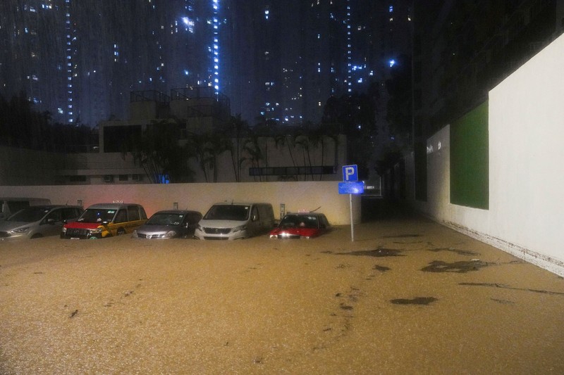 Banjir saat hujan deras di Hong Kong, Selasa (5/8/2025). Pejalan kaki berjalan melewati area yang terendam banjir saat hujan deras di Hong Kong, Selasa (5/8/2025). (REUTERS/Lam Yik)