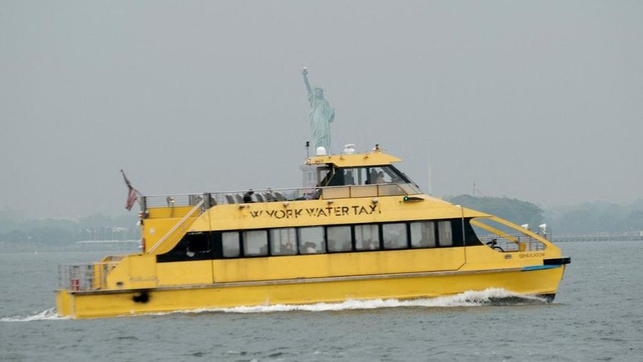 Taksi air melintas di depan Patung Liberty di New York City. (Getty Images via AFP/SPENCER PLATT)