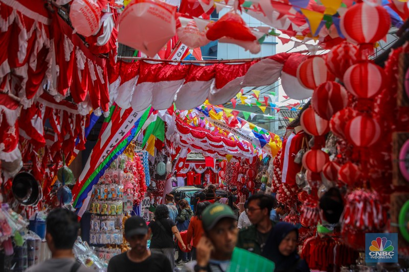 Pedagang melayani pembeli pernak-pernik peringatan Hari Ulang Tahun (HUT) ke-80 Republik Indonesia di kawasam Pasar Jatinegara, Jakarta, Rabu (6/8/2025). (CNBC Indonesia/Faisal Rahman)