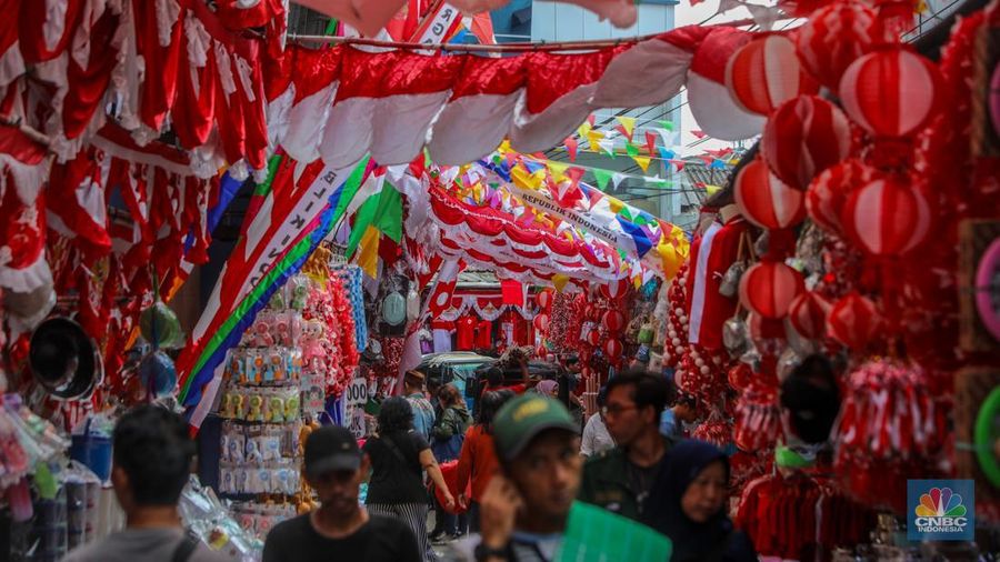 Pedagang melayani pembeli pernak-pernik peringatan Hari Ulang Tahun (HUT) ke-80 Republik Indonesia di kawasam Pasar Jatinegara, Jakarta, Rabu (6/8/2025). (CNBC Indonesia/Faisal Rahman)