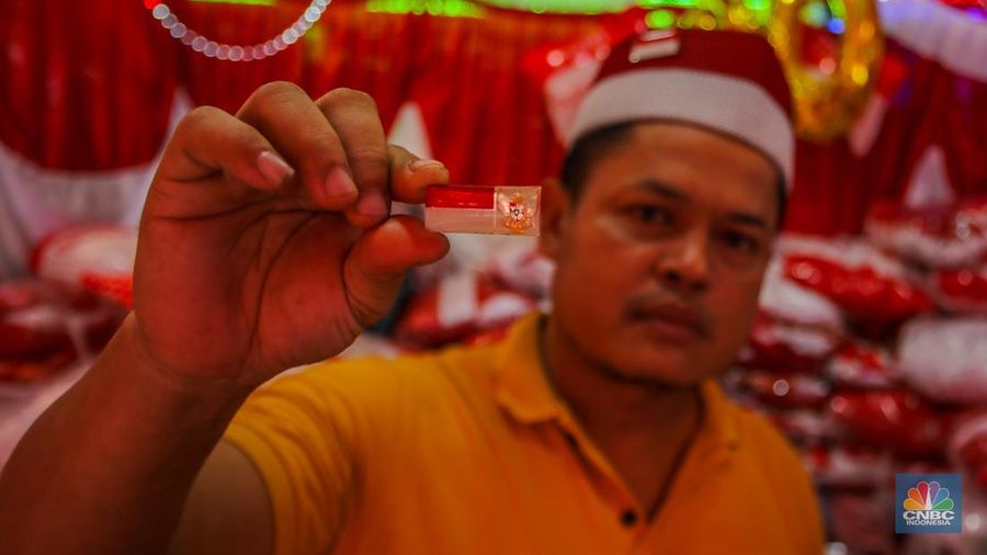 Pedagang melayani pembeli pernak-pernik peringatan Hari Ulang Tahun (HUT) ke-80 Republik Indonesia di kawasam Pasar Jatinegara, Jakarta, Rabu (6/8/2025). (CNBC Indonesia/Faisal Rahman)