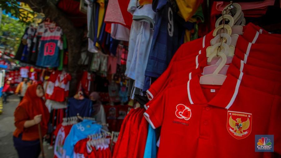 Pedagang melayani pembeli pernak-pernik peringatan Hari Ulang Tahun (HUT) ke-80 Republik Indonesia di kawasam Pasar Jatinegara, Jakarta, Rabu (6/8/2025). (CNBC Indonesia/Faisal Rahman)