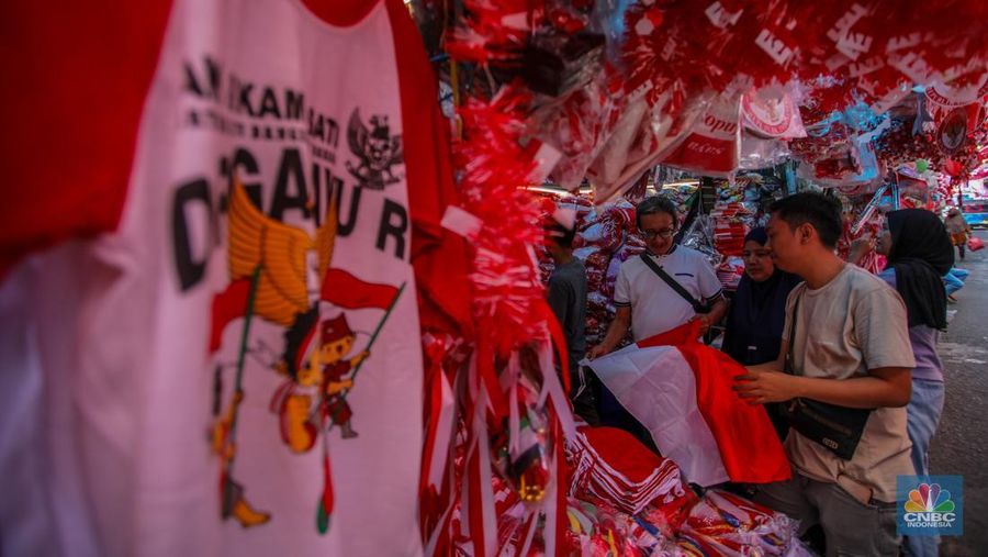 Pedagang melayani pembeli pernak-pernik peringatan Hari Ulang Tahun (HUT) ke-80 Republik Indonesia di kawasam Pasar Jatinegara, Jakarta, Rabu (6/8/2025). (CNBC Indonesia/Faisal Rahman)