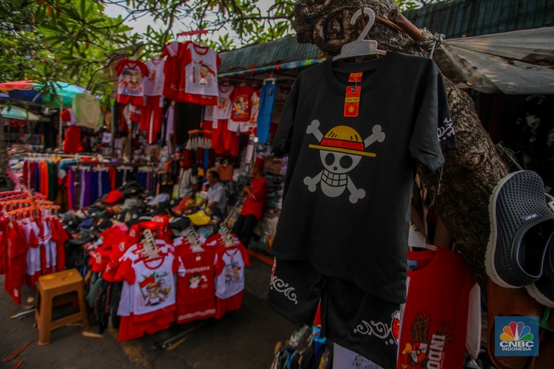 Pedagang melayani pembeli pernak-pernik peringatan Hari Ulang Tahun (HUT) ke-80 Republik Indonesia di kawasam Pasar Jatinegara, Jakarta, Rabu (6/8/2025). (CNBC Indonesia/Faisal Rahman)