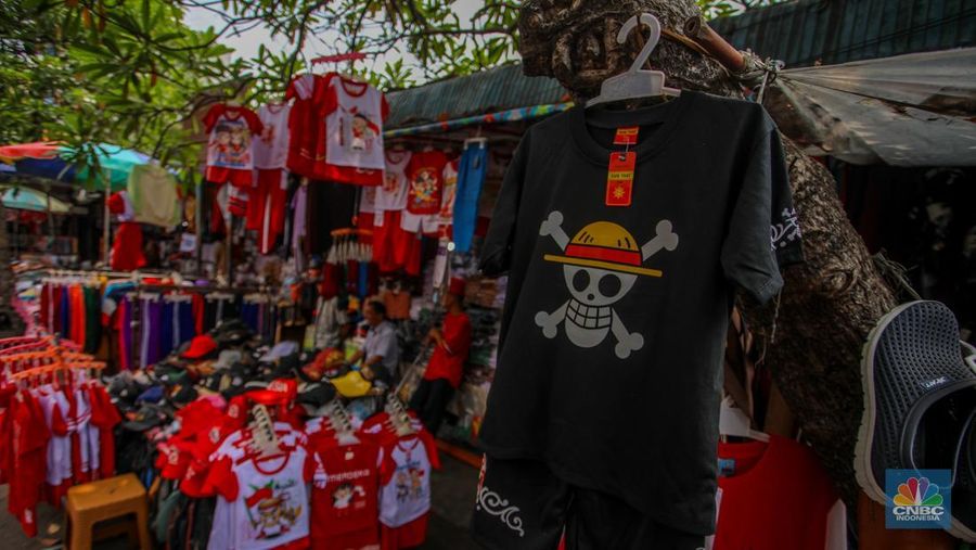 Pedagang melayani pembeli pernak-pernik peringatan Hari Ulang Tahun (HUT) ke-80 Republik Indonesia di kawasam Pasar Jatinegara, Jakarta, Rabu (6/8/2025). (CNBC Indonesia/Faisal Rahman)