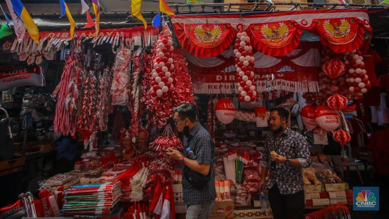 Pedagang melayani pembeli pernak-pernik peringatan Hari Ulang Tahun (HUT) ke-80 Republik Indonesia di kawasam Pasar Jatinegara, Jakarta, Rabu (6/8/2025). (CNBC Indonesia/Faisal Rahman)