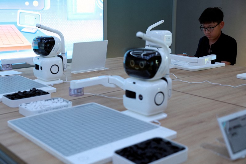 CHINA-ROBOTS/ A staff member works at a section selling Robot World merchandise, during an organised media tour to Robot Mall, a store selling humanoid and other robots, in Beijing, China August 6, 2025. REUTERS/Florence Lo