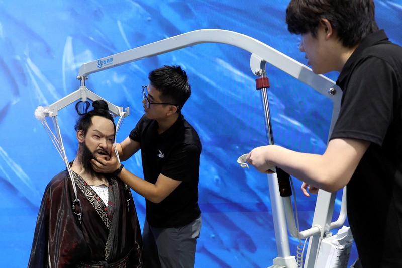 CHINA-ROBOTS/ A staff member works at a section selling Robot World merchandise, during an organised media tour to Robot Mall, a store selling humanoid and other robots, in Beijing, China August 6, 2025. REUTERS/Florence Lo