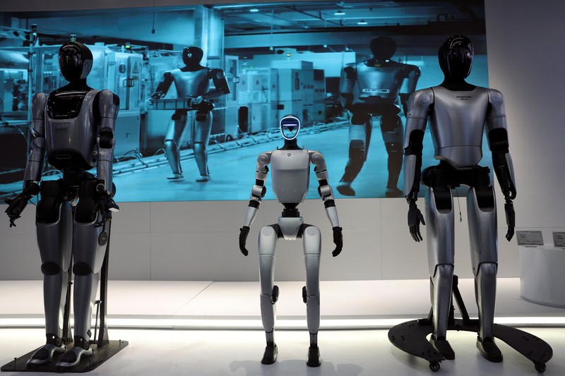 CHINA-ROBOTS/ A staff member works at a section selling Robot World merchandise, during an organised media tour to Robot Mall, a store selling humanoid and other robots, in Beijing, China August 6, 2025. REUTERS/Florence Lo