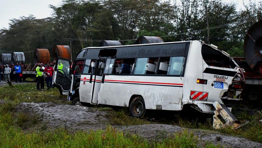 Palang Merah Kenya dan tim penyelamat lainnya berupaya mengeluarkan jenazah seorang penumpang dari reruntuhan bus staf yang bertabrakan di perlintasan kereta api, di Naivasha, Kenya, 7 Agustus 2025. (REUTERS/Stringer)