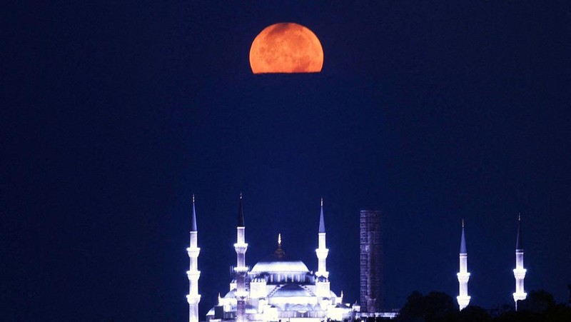 The Sturgeon Moon is seen over the Sultanahmet Mosque, known as the Blue Mosque, in Istanbul, Turkey, August 9, 2025. REUTERS/Dilara Senkaya     TPX IMAGES OF THE DAY