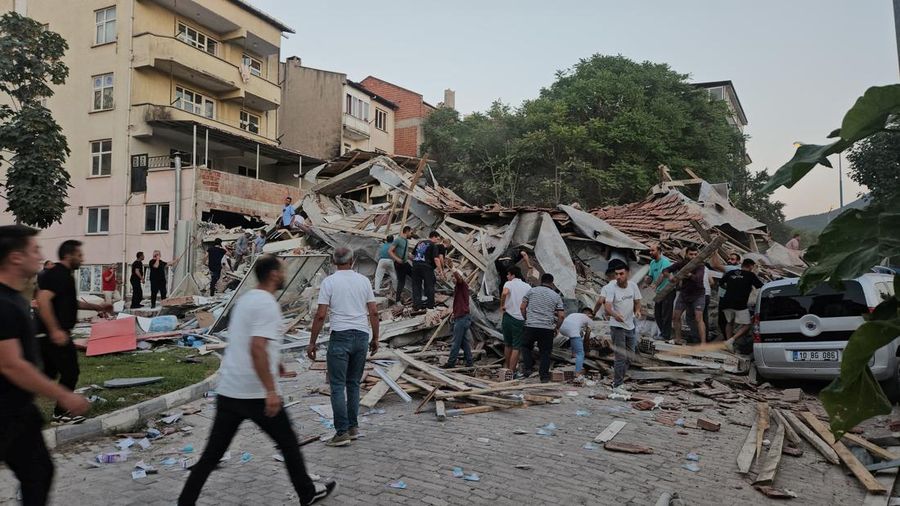 Orang-orang bergegas ke bangunan yang runtuh untuk mencari korban selamat setelah gempa bumi di Sindirgi di provinsi Balikesir barat, Turki, 10 Agustus 2025. (Ihlas News Agency (IHA) via REUTERS ATTENTION EDITORS)