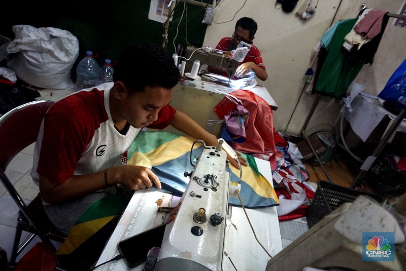 Pekerja melipat bendera di usaha konveksi rumahan yang memproduksi bendera umbul-umbul merah putih, topi, hingga kaos di kawasan Tangerang Selatan, Banten. Pekerja melipat bendera di usaha konveksi rumahan yang memproduksi bendera umbul-umbul merah putih, topi, hingga kaos di kawasan Tangerang Selatan, Banten, Senin (11/8/2025). (CNBC Indonesia/Muhammad Sabki)