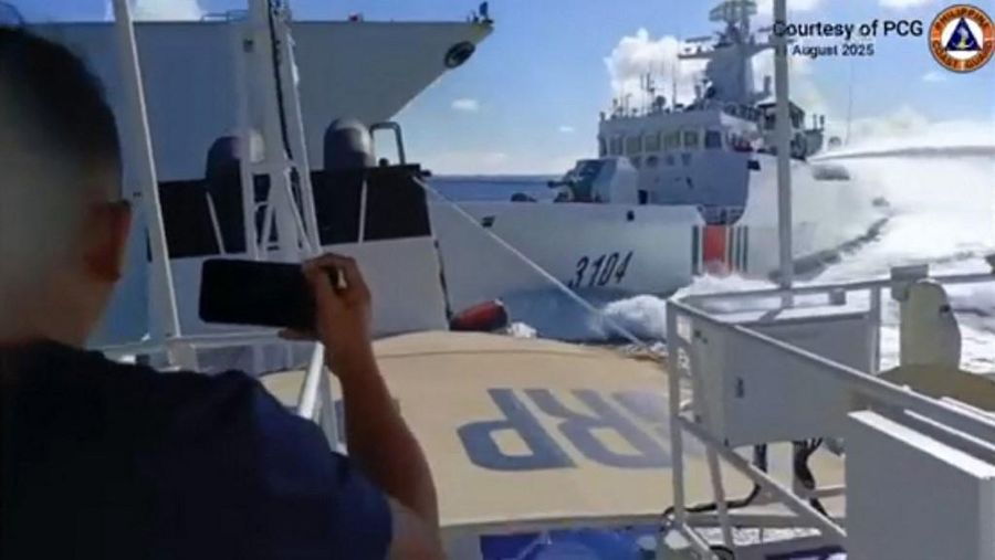 This handout video grab released and taken on August 11, 2025 by the Philippine Coast Guard shows an incident between a Chinese Navy vessel (L) and a Chinese Coast Guard ship (R) as seen from a Philippine fisheries boat near Scarborough Shoal in the disputed South China Sea. A Chinese navy vessel collided with one from its coast guard while chasing a Philippines patrol boat in the South China Sea, Manila said on August 11, releasing dramatic video footage of the confrontation. (Photo by Handout / Philippine Coast Guard (PCG) / AFP) / RESTRICTED TO EDITORIAL USE - MANDATORY CREDIT