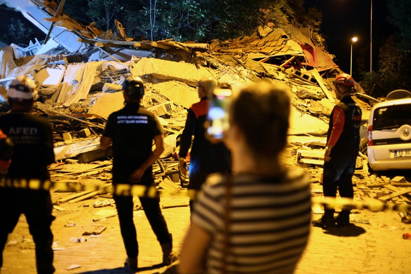 Orang-orang bergegas ke bangunan yang runtuh untuk mencari korban selamat setelah gempa bumi di Sindirgi di provinsi Balikesir barat, Turki, 10 Agustus 2025. (Ihlas News Agency (IHA) via REUTERS ATTENTION EDITORS)