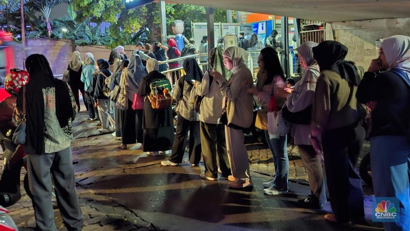 Calon penumpang antre di Halte TranJakarta Tegal Parang, Jakarta, Selasa (12/8/2025). (CNBC Indonesia/Kartini Bohang)