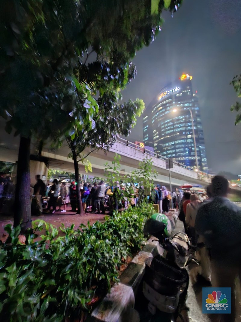 Calon penumpang antre di Halte TranJakarta Tegal Parang, Jakarta, Selasa (12/8/2025). (CNBC Indonesia/Kartini Bohang)