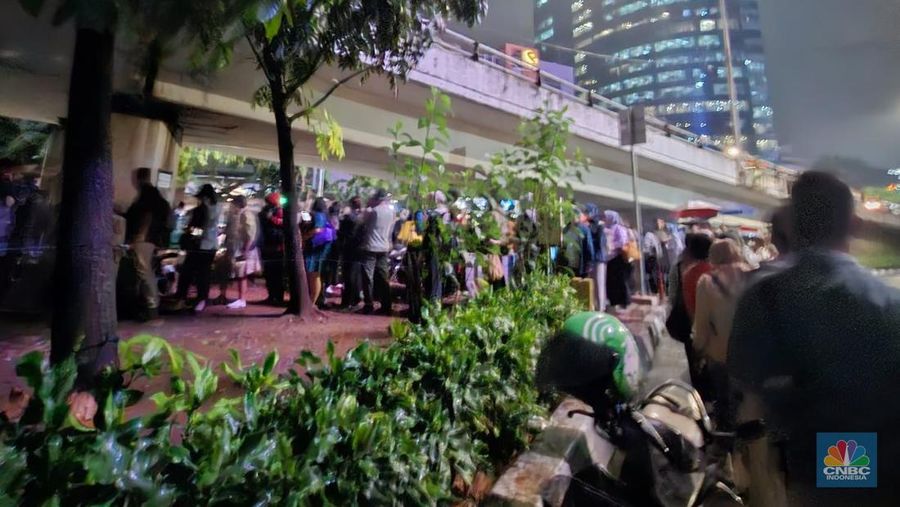 Calon penumpang antre di Halte TranJakarta Tegal Parang, Jakarta, Selasa (12/8/2025). (CNBC Indonesia/Kartini Bohang)