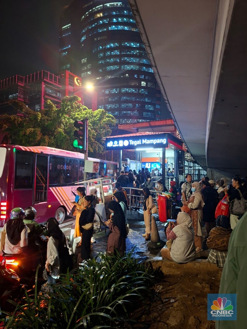 Calon penumpang antre di Halte TranJakarta Tegal Parang, Jakarta, Selasa (12/8/2025). (CNBC Indonesia/Kartini Bohang)