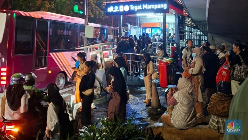 Calon penumpang antre di Halte TranJakarta Tegal Parang, Jakarta, Selasa (12/8/2025). (CNBC Indonesia/Kartini Bohang)