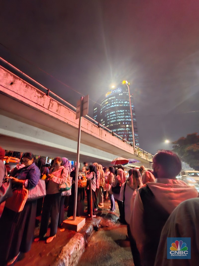 Calon penumpang antre di Halte TranJakarta Tegal Parang, Jakarta, Selasa (12/8/2025). (CNBC Indonesia/Kartini Bohang)