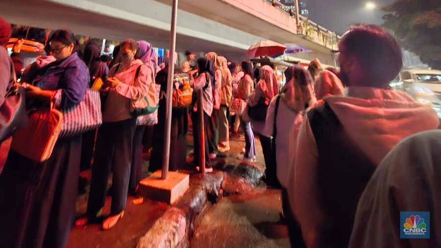 Calon penumpang antre di Halte TranJakarta Tegal Parang, Jakarta, Selasa (12/8/2025). (CNBC Indonesia/Kartini Bohang)