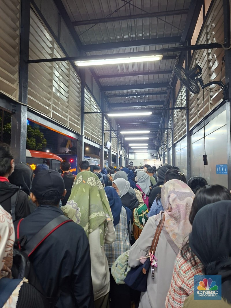 Calon penumpang antre di Halte TranJakarta Tegal Parang, Jakarta, Selasa (12/8/2025). (CNBC Indonesia/Kartini Bohang)