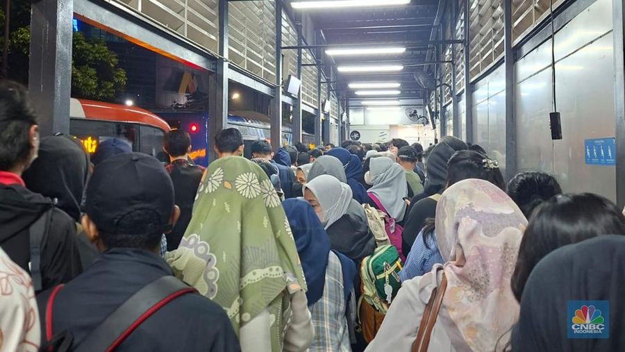 Calon penumpang antre di Halte TranJakarta Tegal Parang, Jakarta, Selasa (12/8/2025). (CNBC Indonesia/Kartini Bohang)