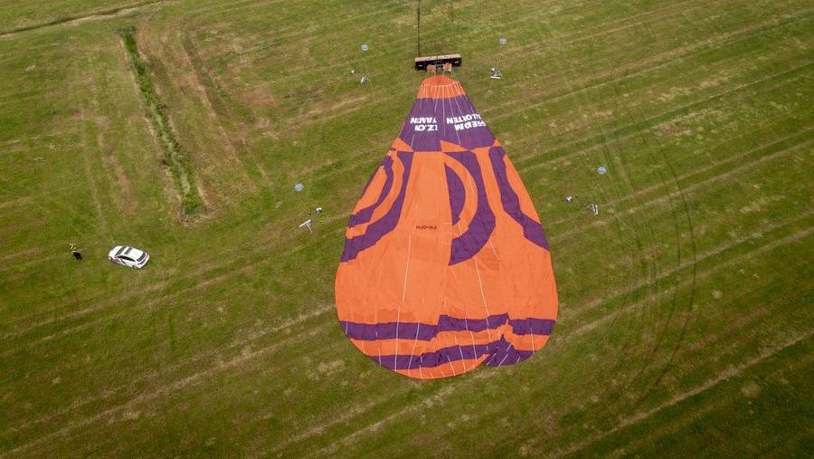 Dutch police officers stand at the scene of a hot air balloon accident near De Hoeve on August 14, 2025, following a crash that caused one death and several injured. (Photo by Jilmer Postma / ANP / AFP) / Netherlands OUT