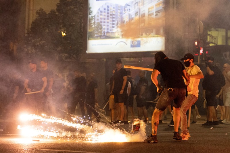 Orang-orang bereaksi di samping ledakan kembang api, selama kebuntuan antara pendukung partai yang berkuasa dan pengunjuk rasa anti-pemerintah di Beograd, Serbia, 14 Agustus 2025. (REUTERS/Djordje Kojadinovic)