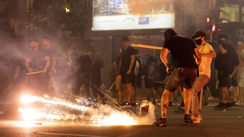 Orang-orang bereaksi di samping ledakan kembang api, selama kebuntuan antara pendukung partai yang berkuasa dan pengunjuk rasa anti-pemerintah di Beograd, Serbia, 14 Agustus 2025. (REUTERS/Djordje Kojadinovic)
