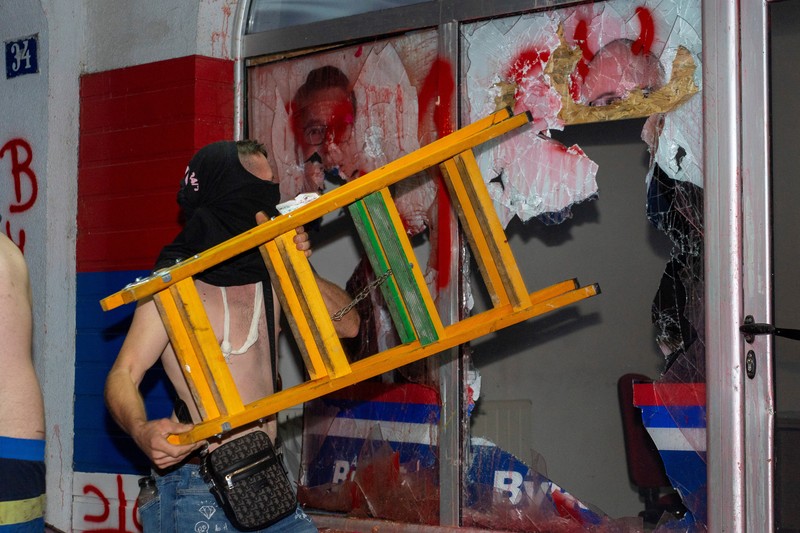 Orang-orang bereaksi di samping ledakan kembang api, selama kebuntuan antara pendukung partai yang berkuasa dan pengunjuk rasa anti-pemerintah di Beograd, Serbia, 14 Agustus 2025. (REUTERS/Djordje Kojadinovic)