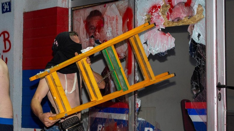 Orang-orang bereaksi di samping ledakan kembang api, selama kebuntuan antara pendukung partai yang berkuasa dan pengunjuk rasa anti-pemerintah di Beograd, Serbia, 14 Agustus 2025. (REUTERS/Djordje Kojadinovic)