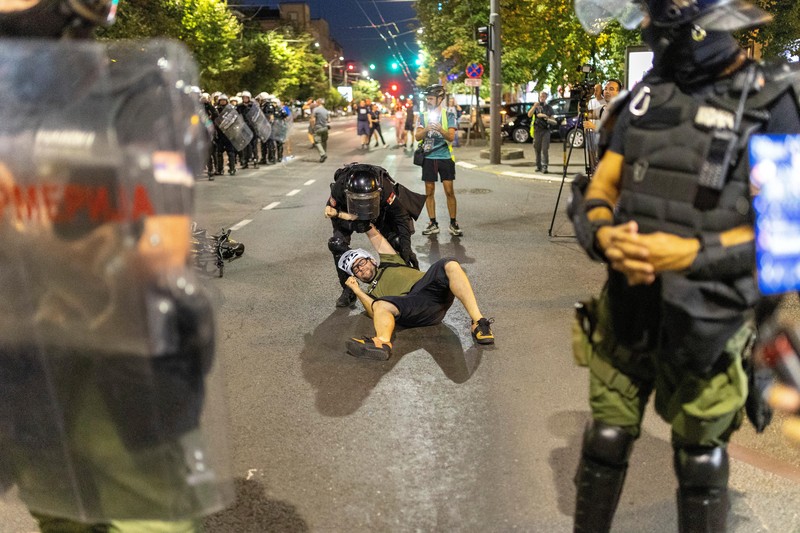 Orang-orang bereaksi di samping ledakan kembang api, selama kebuntuan antara pendukung partai yang berkuasa dan pengunjuk rasa anti-pemerintah di Beograd, Serbia, 14 Agustus 2025. (REUTERS/Djordje Kojadinovic)