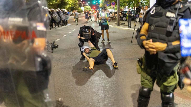 Orang-orang bereaksi di samping ledakan kembang api, selama kebuntuan antara pendukung partai yang berkuasa dan pengunjuk rasa anti-pemerintah di Beograd, Serbia, 14 Agustus 2025. (REUTERS/Djordje Kojadinovic)