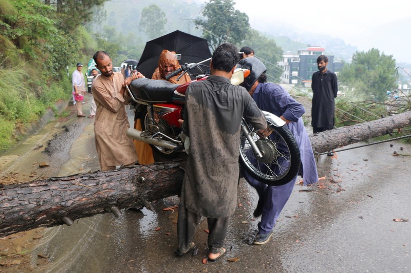 Orang-orang berkumpul di lokasi banjir bandang di Tehsil Salarzai di distrik Bajaur, Pakistan. Korban jiwa akibat hujan monsun deras yang memicu tanah longsor dan banjir bandang di wilayah utara Pakistan terus bertambah. Hingga Sabtu, 16 Agustus 2025, sedikitnya 194 orang dilaporkan meninggal. (REUTERS/Stringer)