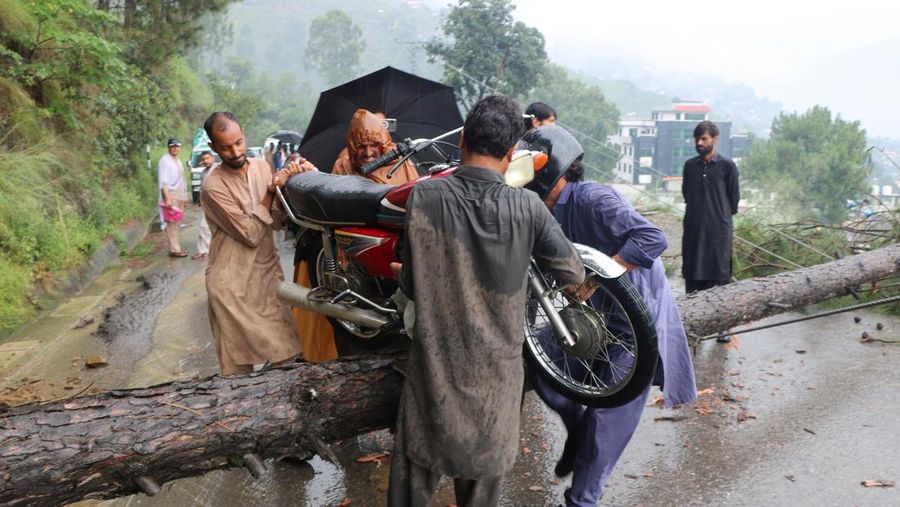 Orang-orang berkumpul di lokasi banjir bandang di Tehsil Salarzai di distrik Bajaur, Pakistan. Korban jiwa akibat hujan monsun deras yang memicu tanah longsor dan banjir bandang di wilayah utara Pakistan terus bertambah. Hingga Sabtu, 16 Agustus 2025, sedikitnya 194 orang dilaporkan meninggal. (REUTERS/Stringer)