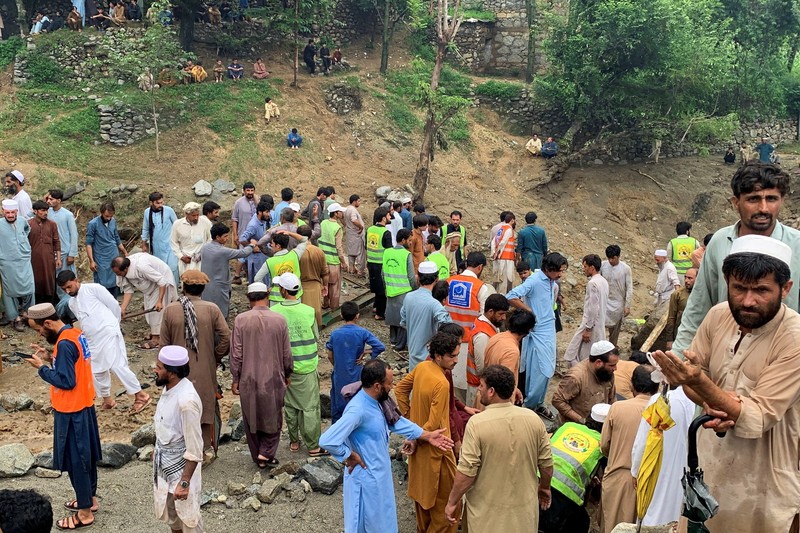 Orang-orang berkumpul di lokasi banjir bandang di Tehsil Salarzai di distrik Bajaur, Pakistan. Korban jiwa akibat hujan monsun deras yang memicu tanah longsor dan banjir bandang di wilayah utara Pakistan terus bertambah. Hingga Sabtu, 16 Agustus 2025, sedikitnya 194 orang dilaporkan meninggal. (REUTERS/Stringer)