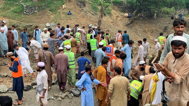 Orang-orang berkumpul di lokasi banjir bandang di Tehsil Salarzai di distrik Bajaur, Pakistan. Korban jiwa akibat hujan monsun deras yang memicu tanah longsor dan banjir bandang di wilayah utara Pakistan terus bertambah. Hingga Sabtu, 16 Agustus 2025, sedikitnya 194 orang dilaporkan meninggal. (REUTERS/Stringer)