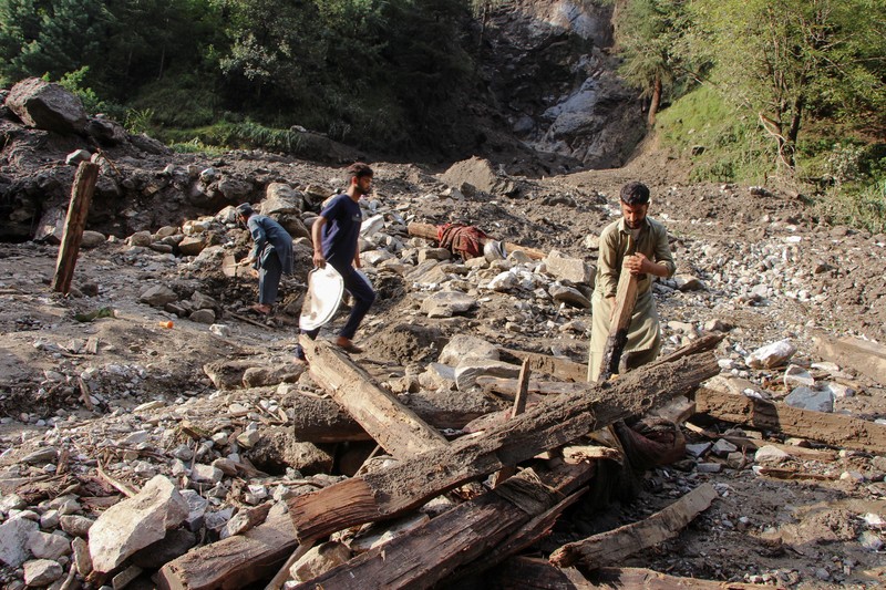 Orang-orang berkumpul di lokasi banjir bandang di Tehsil Salarzai di distrik Bajaur, Pakistan. Korban jiwa akibat hujan monsun deras yang memicu tanah longsor dan banjir bandang di wilayah utara Pakistan terus bertambah. Hingga Sabtu, 16 Agustus 2025, sedikitnya 194 orang dilaporkan meninggal. (REUTERS/Stringer)