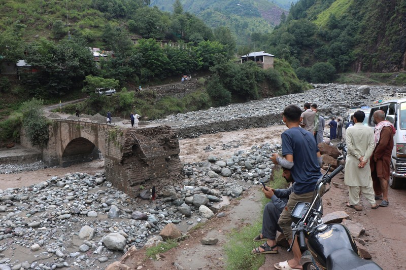 Orang-orang berkumpul di lokasi banjir bandang di Tehsil Salarzai di distrik Bajaur, Pakistan. Korban jiwa akibat hujan monsun deras yang memicu tanah longsor dan banjir bandang di wilayah utara Pakistan terus bertambah. Hingga Sabtu, 16 Agustus 2025, sedikitnya 194 orang dilaporkan meninggal. (REUTERS/Stringer)